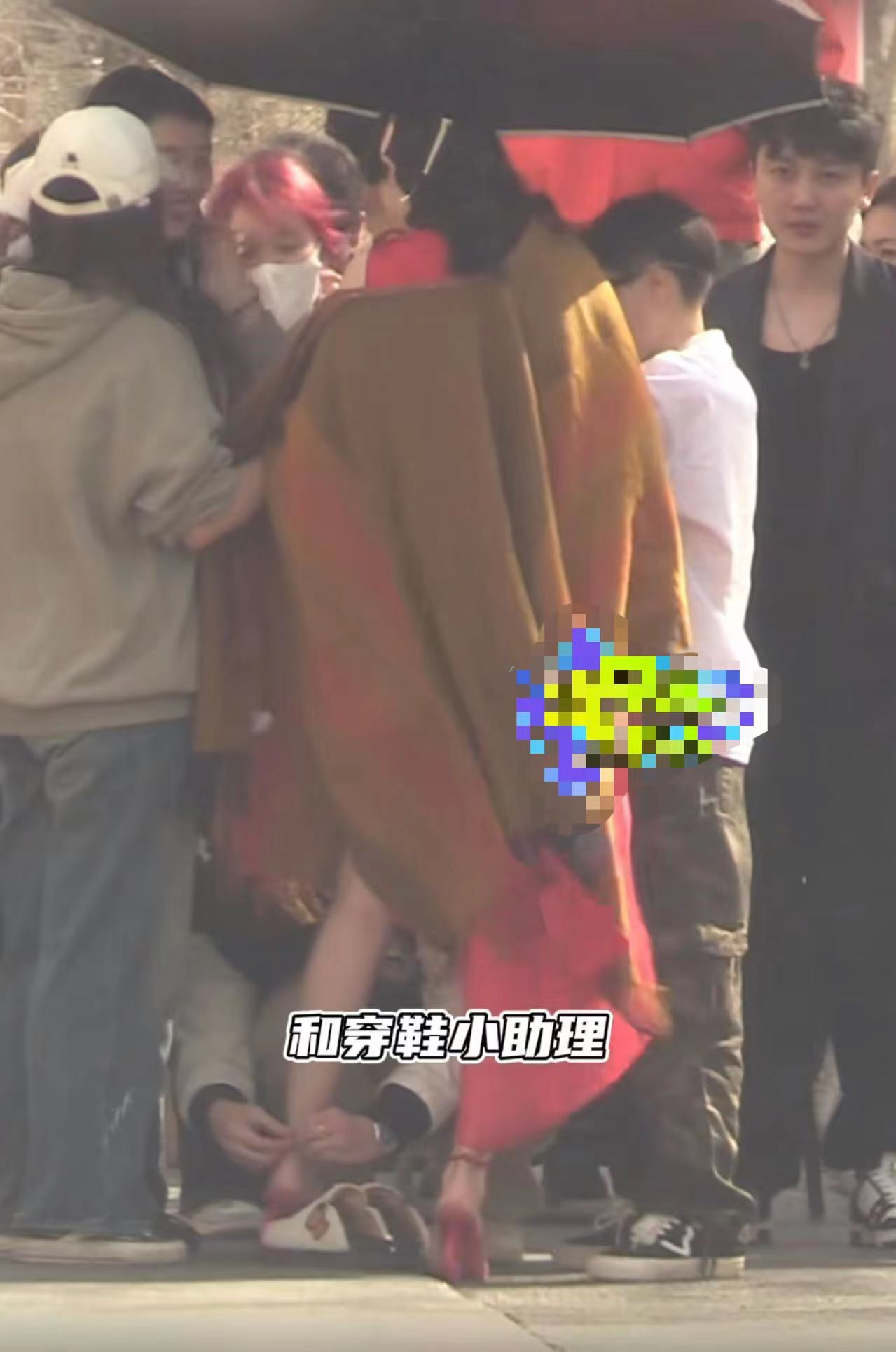 古力娜扎的近况如何， 穿高开叉红裙秀美腿，露底裤险走光，助理蹲地为其穿鞋